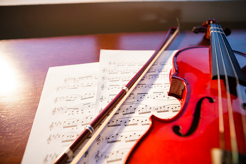 High angle view of violin with sheet music on table at classroom