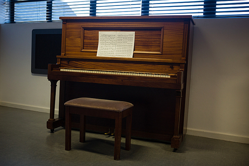 Wooden piano against window in clasroom at school