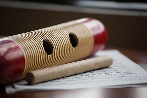 Close up of musical instrument with sheet music on wooden table in classroom