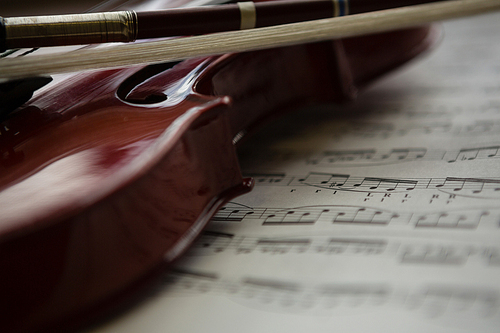 Close up of violin with sheet music on table at classroom