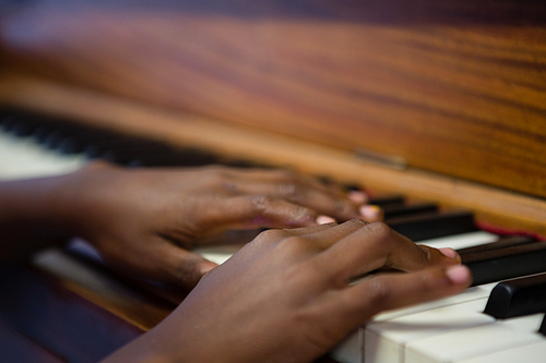 Close up of boy playing piano in classroom at school