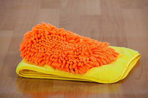 Close-up of doormat and napkin on wooden floor