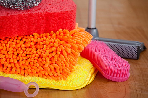 Close-up of various housekeeping supplies on wooden floor