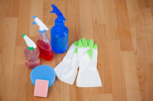 Close-up of glove with cleaning equipment on wooden floor