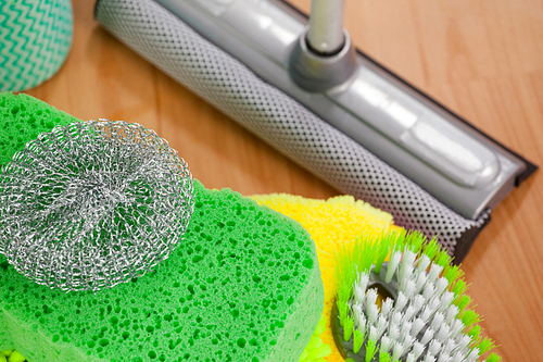 Close-up of various cleaning equipment on wooden floor