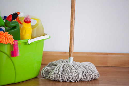 Mop and cleaning equipment on wooden floor against wall