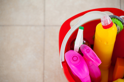 Close-up of bucket with cleaning supplies on tile floor