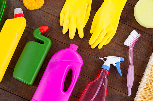 Close-up of various cleaning equipment arranged on wooden floor