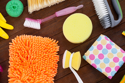 Close-up of various cleaning equipment arranged on wooden floor