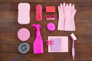 Pink color cleaning equipment arranged on wooden floor