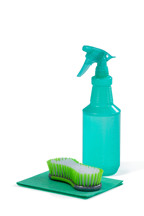 Detergent spray bottle and scouring pad on white background