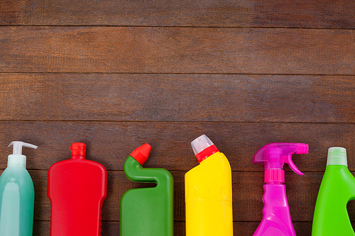 Various detergent bottles arranged on a wooden floor