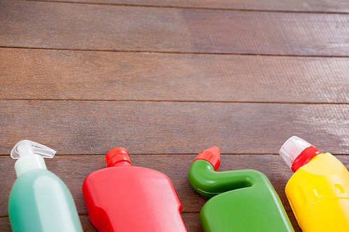 Various detergent bottles arranged on a wooden floor