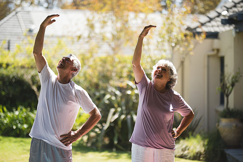 Smiling senior couple exercising together on sunny day