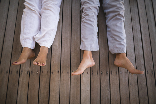 High angle low section of senior couple lying on wooden floor at porch