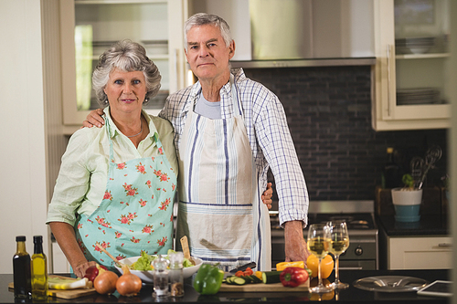 Portrait of senior couple standing together in kitchen at home