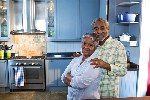 Portrait of senior couple standing in kitchen at home