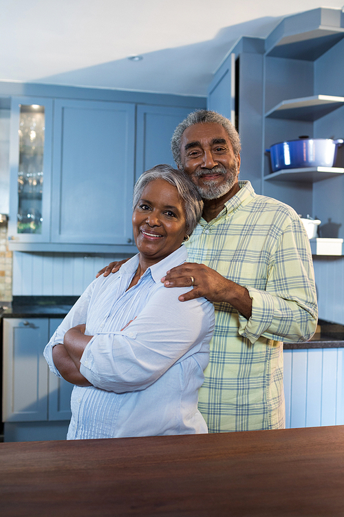 Portrait of man and woman standing in kitchen at home