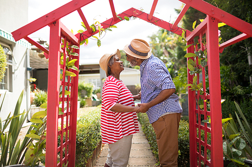 Side view of senior couple talking while standing in yard