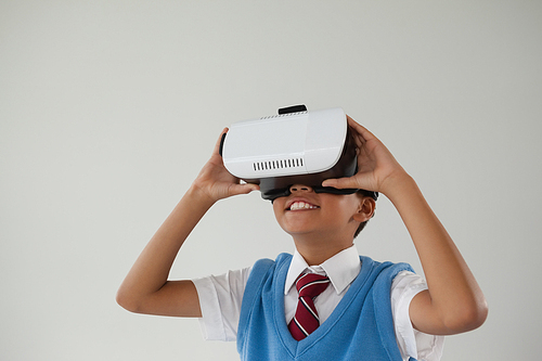 Schoolboy using virtual reality headset against white background