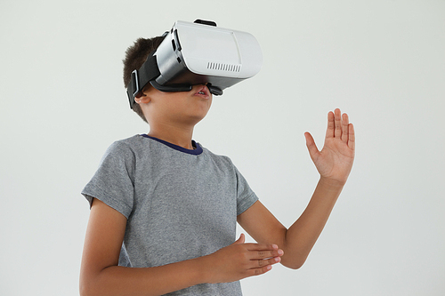 Schoolboy using virtual reality headset against white background