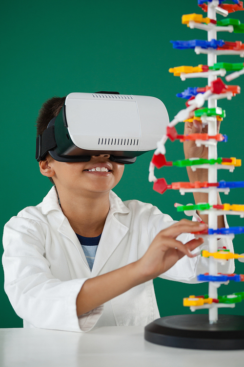 Smiling schoolboy using digital tablet in laboratory at school