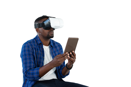 Man using virtual reality headset and digital tablet against white background