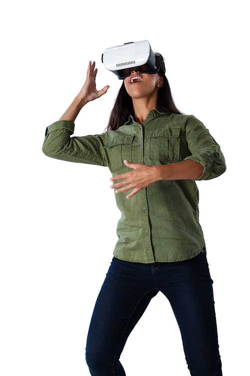 Woman gesturing while using virtual reality headset against white background