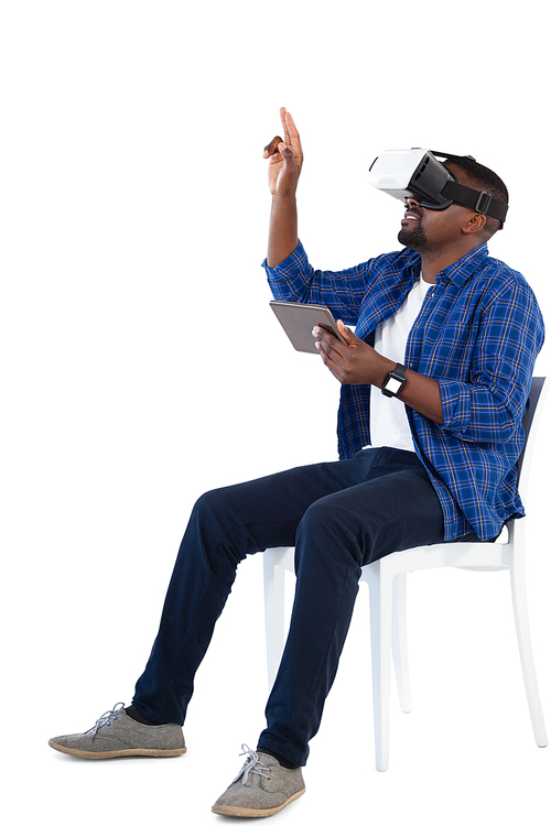 Man gesturing while using virtual reality headset and digital tablet against white background