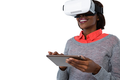 Woman wearing vr glasses while using tablet computer against white background