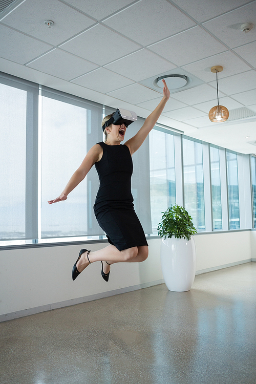 Young female executive using virtual reality headset in office