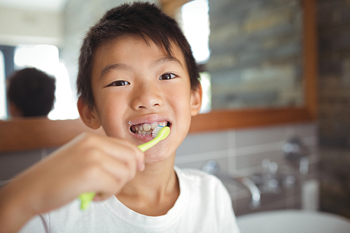 Boy brushing his teeth in bathroom at home