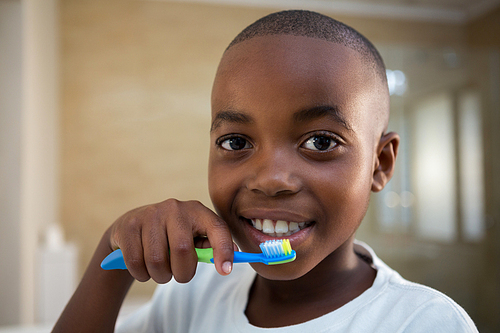 Close-up portrait of boy with toothbrush at bathroom