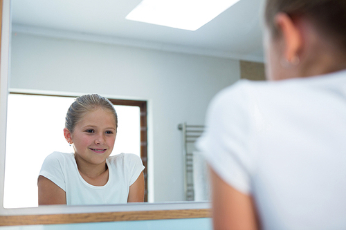 Girl standing while reflecting in mirror