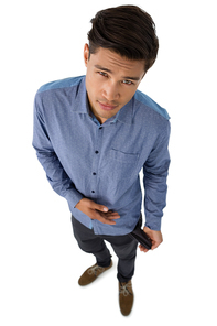 High angle portrait of businessman showing empty pocket while standing against white background