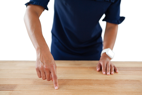 Mid section of businesswoman touching invisible screen on wooden table