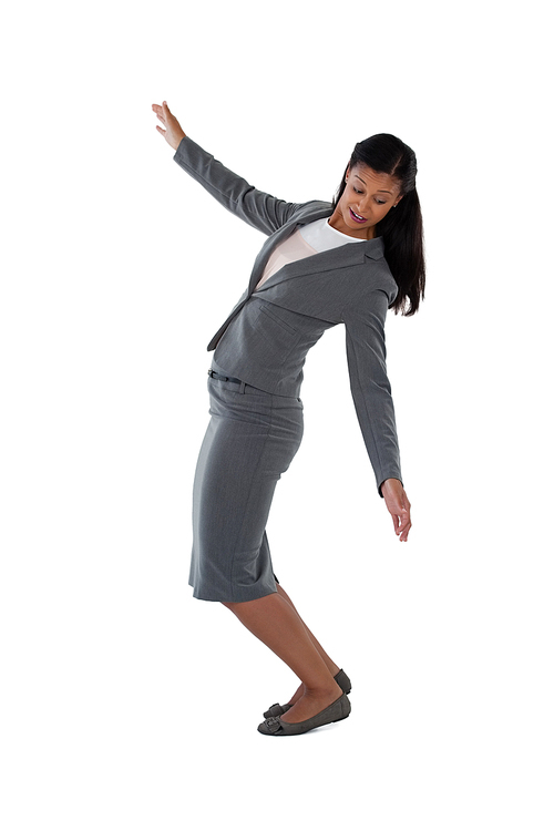 Businesswoman balancing while walking against white background