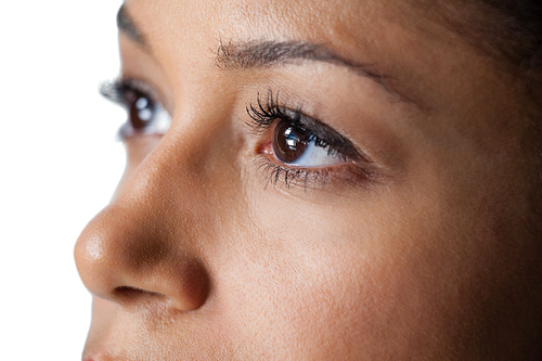 Close-up of womans eye and nose against white background