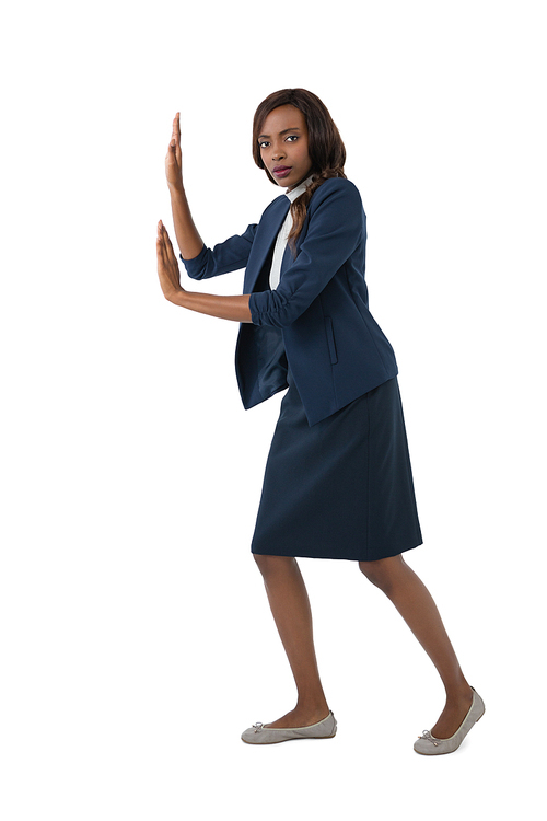 Portrait of young businesswoman pushing something on white background