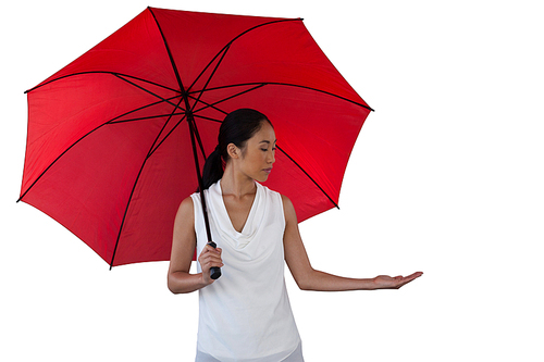 young woman holding umbrella while standing against white background