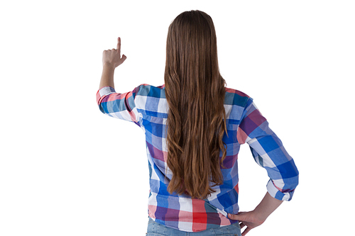 Rear view of girl pressing an invisible virtual screen against white background