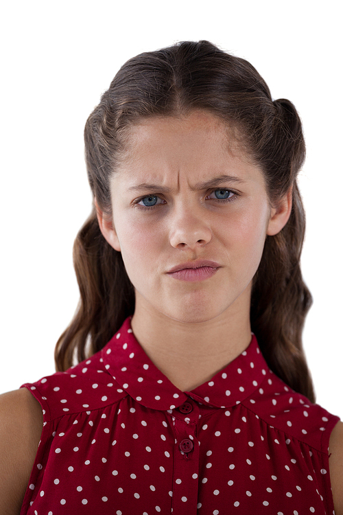 Confused teenage girl standing against white background