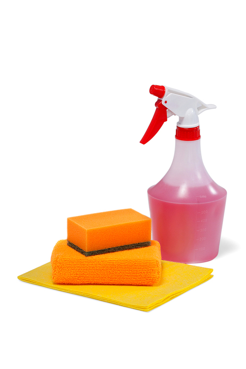 Detergent spray bottle, scouring pad and cleaning pad arranged on white background
