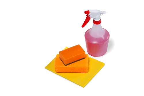 Close-up of spray bottle and scouring pad on white background