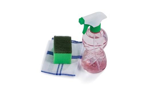Close-up of spray bottle, scouring pad and napkin cloth on white background