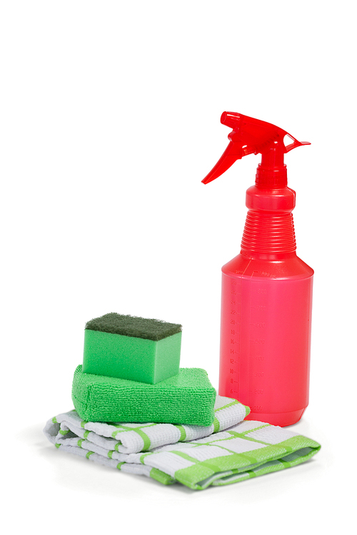 Detergent spray bottle, scouring pad and napkin cloth arranged on white background