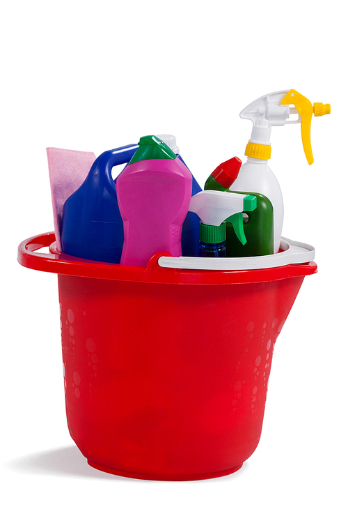 Various household cleaning supplies in a bucket on white background
