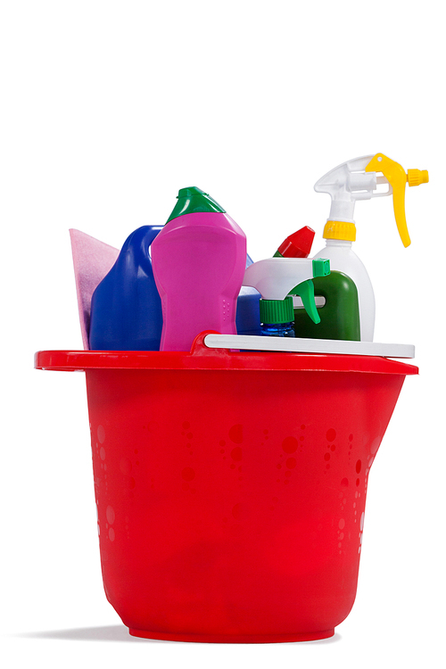 Various household cleaning supplies in a bucket on white background
