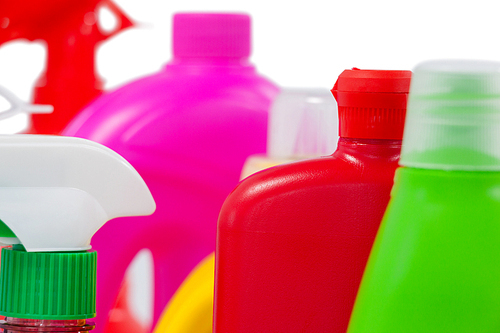 Close-up of various detergent containers arranged on white background