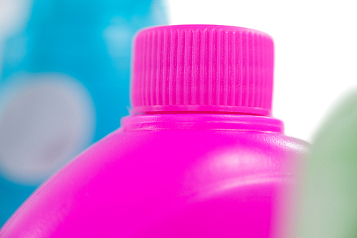 Close-up of pink detergent container on white background